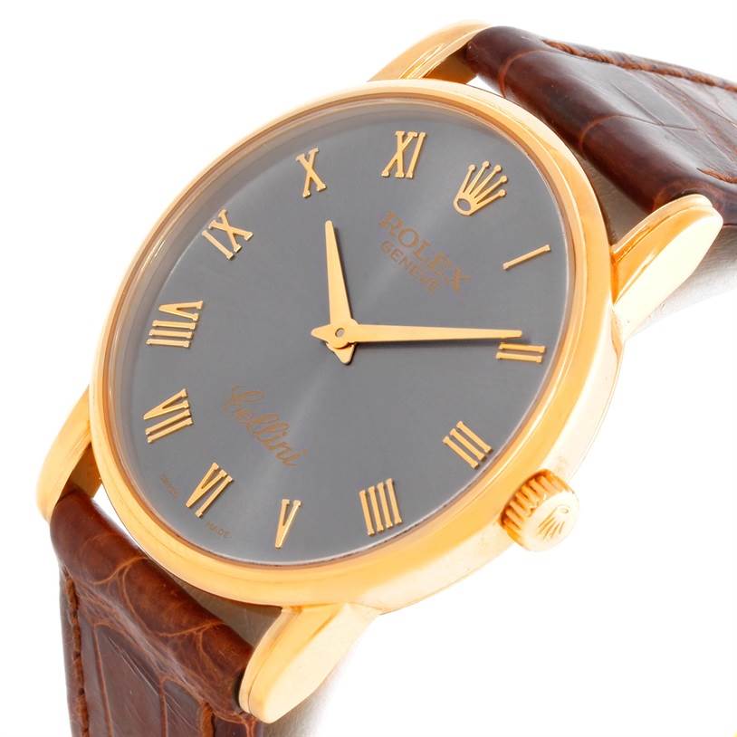 The Rolex Cellini 5116 Men's Yellow Gold Grey Dial 5116 Men's Yellow Gold Grey Dial watch is shown at an angle displaying the face, gold Roman numeral markers, gold case, and brown leather strap.