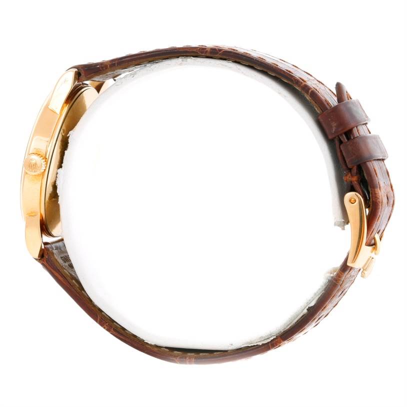 This side view of the Rolex Cellini 5116 Men's Yellow Gold Grey Dial 5116 Men's Yellow Gold Grey Dial watch shows the crown, case, and leather strap.