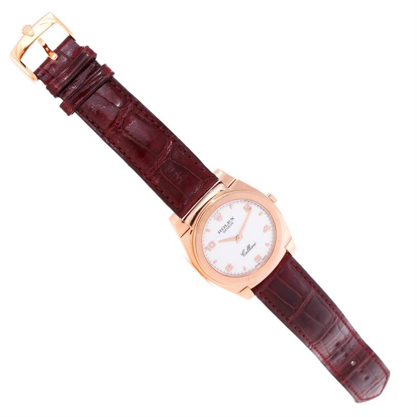This image shows a top view of a Rolex Cellini 5330 Men's Rose Gold White Dial 5330 Men's Rose Gold White Dial watch with a brown leather strap and a gold case.