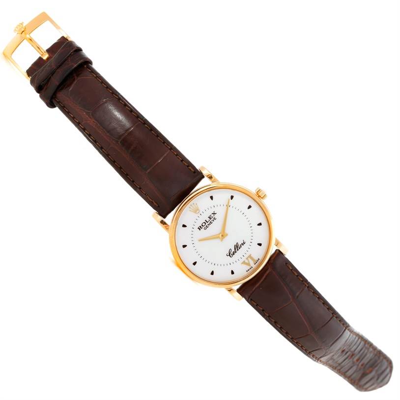 The image shows a top-down view of a Rolex Cellini 5115 Men
s Yellow Gold Silver Dial 5115 Men
s Yellow Gold Silver Dial watch, featuring its dial, gold case, and brown leather strap.
