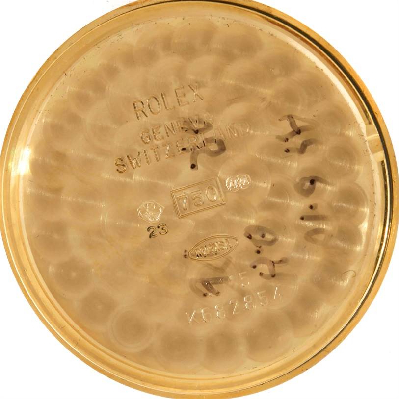 This image shows the inside case back of a Rolex Cellini 5115 Men
s Yellow Gold Silver Dial 5115 Men
s Yellow Gold Silver Dial watch, featuring engravings and hallmarks from a top-down angle.