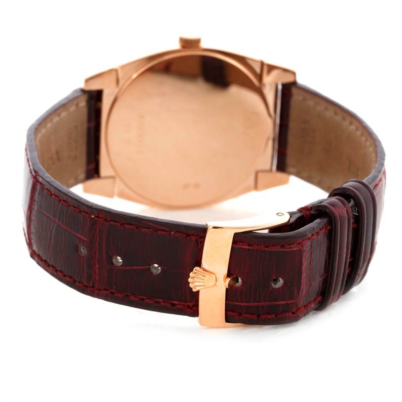 The Rolex Cellini 5320 Rose Gold White Dial 5320 Rose Gold White Dial watch is shown from a rear angle, highlighting its back case and brown leather strap with an engraved clasp.