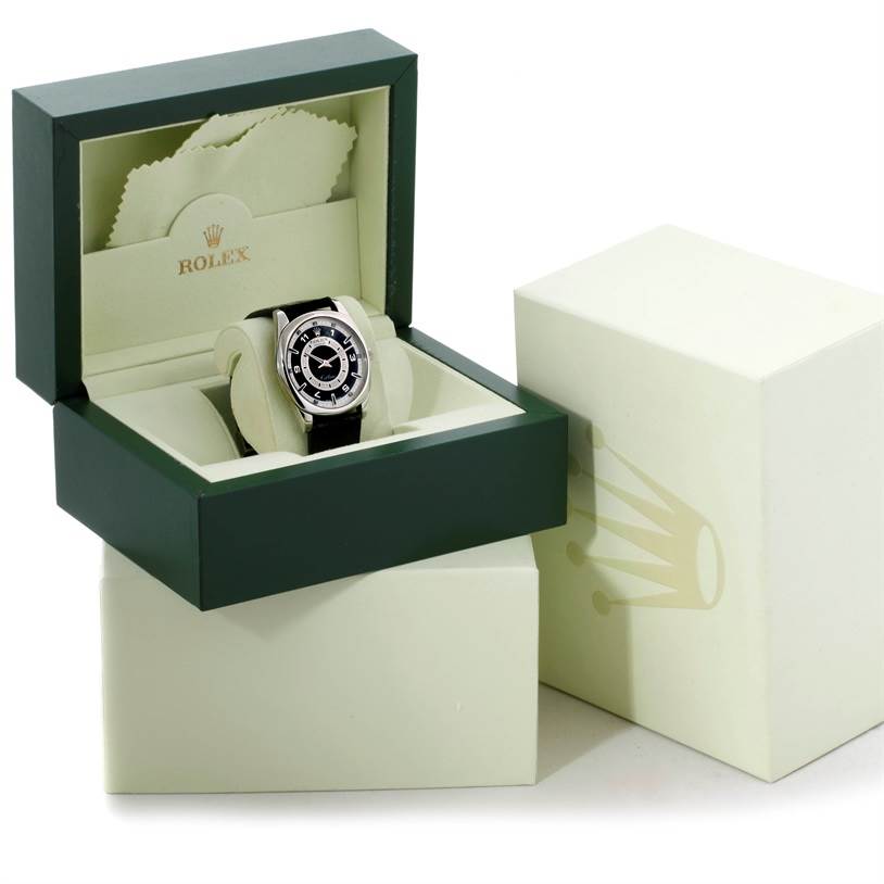 The Rolex Cellini 4243 Men's White Gold Black Dial 4243 Men's White Gold Black Dial watch is shown at an angle inside its open green box, along with an outer box and cleaning cloth.