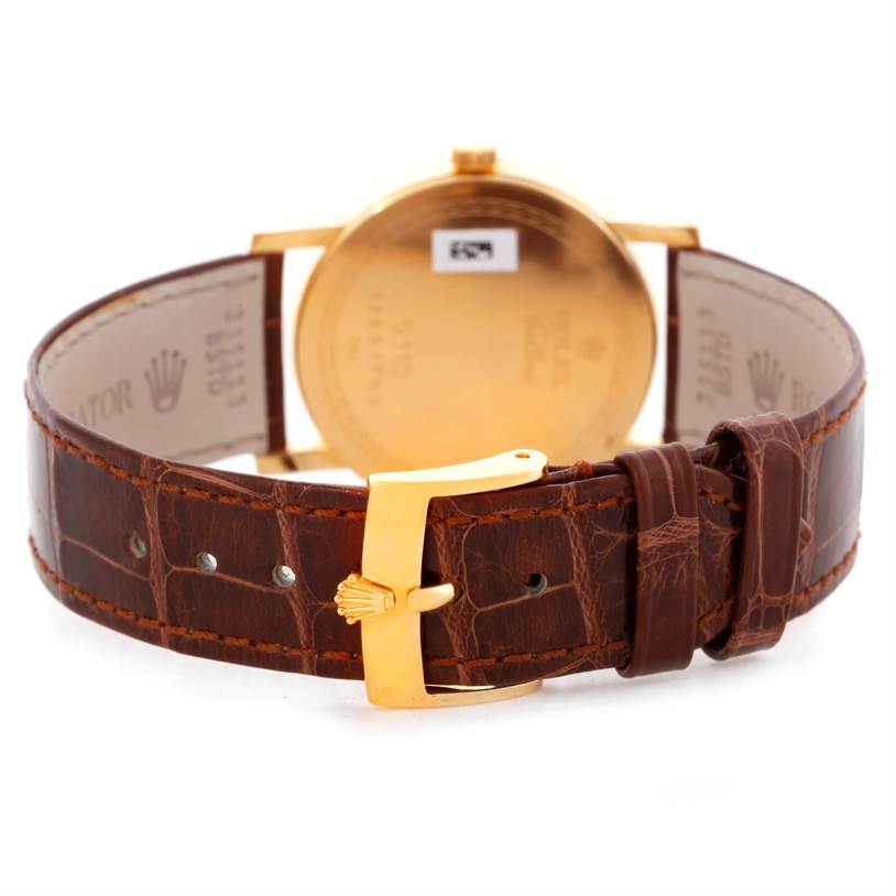 The image shows the back and clasp of a Rolex Cellini 5115 Men
s Yellow Gold Silver Dial 5115 Men
s Yellow Gold Silver Dial watch, highlighting the leather strap and gold buckle.