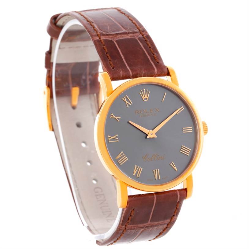 The Rolex Cellini 5115 Men's Yellow Gold Grey Dial 5115 Men's Yellow Gold Grey Dial watch is shown at a three-quarter angle highlighting its face, gold case, brown leather strap, and Roman numeral markers.