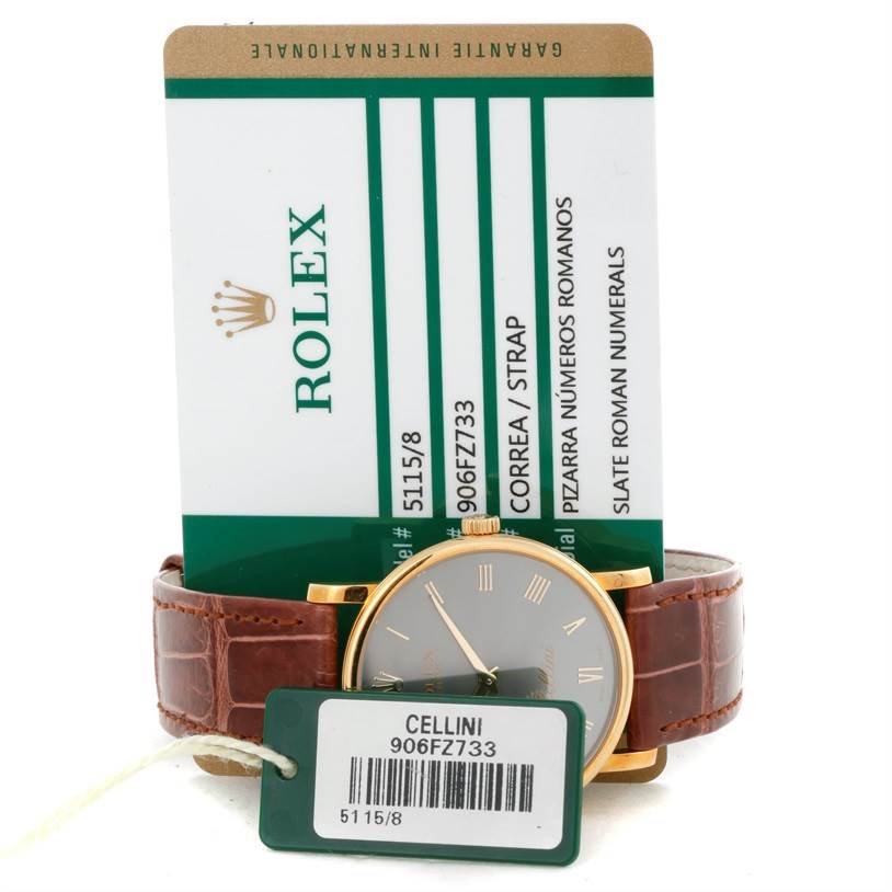 The Rolex Cellini 5115 Men's Yellow Gold Grey Dial 5115 Men's Yellow Gold Grey Dial watch is shown front-facing, highlighting its dial and leather strap, along with its warranty card.