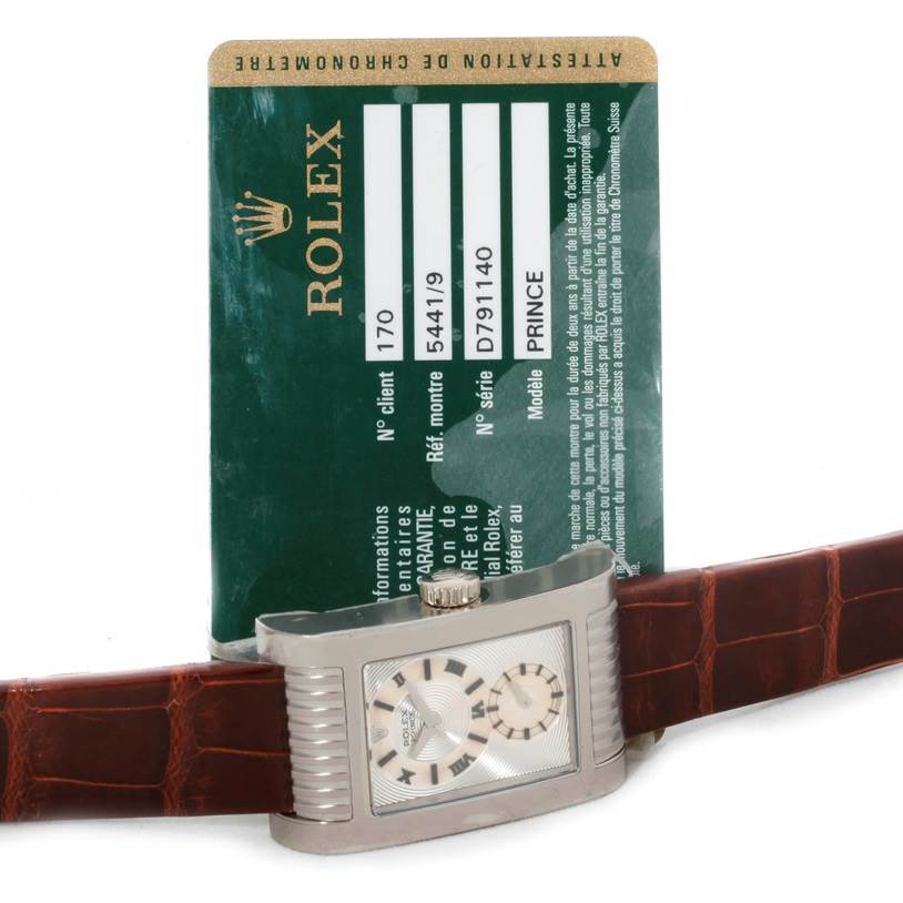 This image shows a Rolex Cellini 5441 Men's White Gold Silver Dial 5441 Men's White Gold Silver Dial watch with a brown leather strap, positioned in front of its authenticity card.