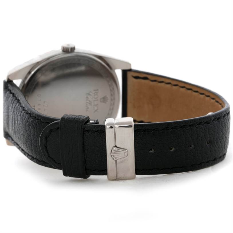 This image shows the back of a Rolex Cellini Men's White Gold Black Dial Men's White Gold Black Dial watch and part of its black leather strap with a buckle.