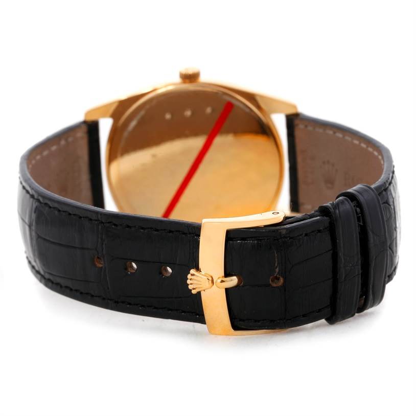 The image shows the back of a Rolex Cellini 4233 Men
s Yellow Gold Black Dial 4233 Men
s Yellow Gold Black Dial watch, focusing on the gold case and black leather strap with a gold buckle.