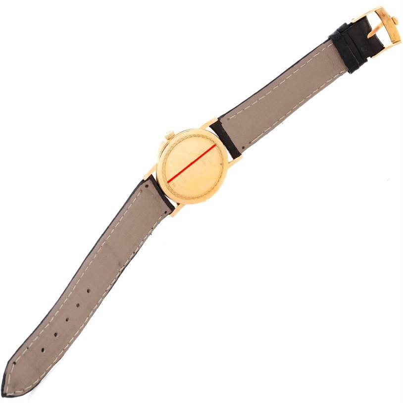 The image shows a top-view angle of a Rolex Cellini 5115 Men
s Yellow Gold Champagne Dial 5115 Men
s Yellow Gold Champagne Dial watch with a gold case and black leather strap.