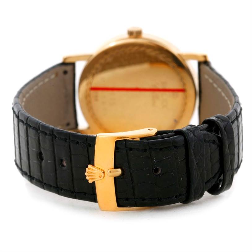 The image shows the back view of a Rolex Cellini 5115 Men
s Yellow Gold Champagne Dial 5115 Men
s Yellow Gold Champagne Dial watch, highlighting its black leather strap and gold buckle.