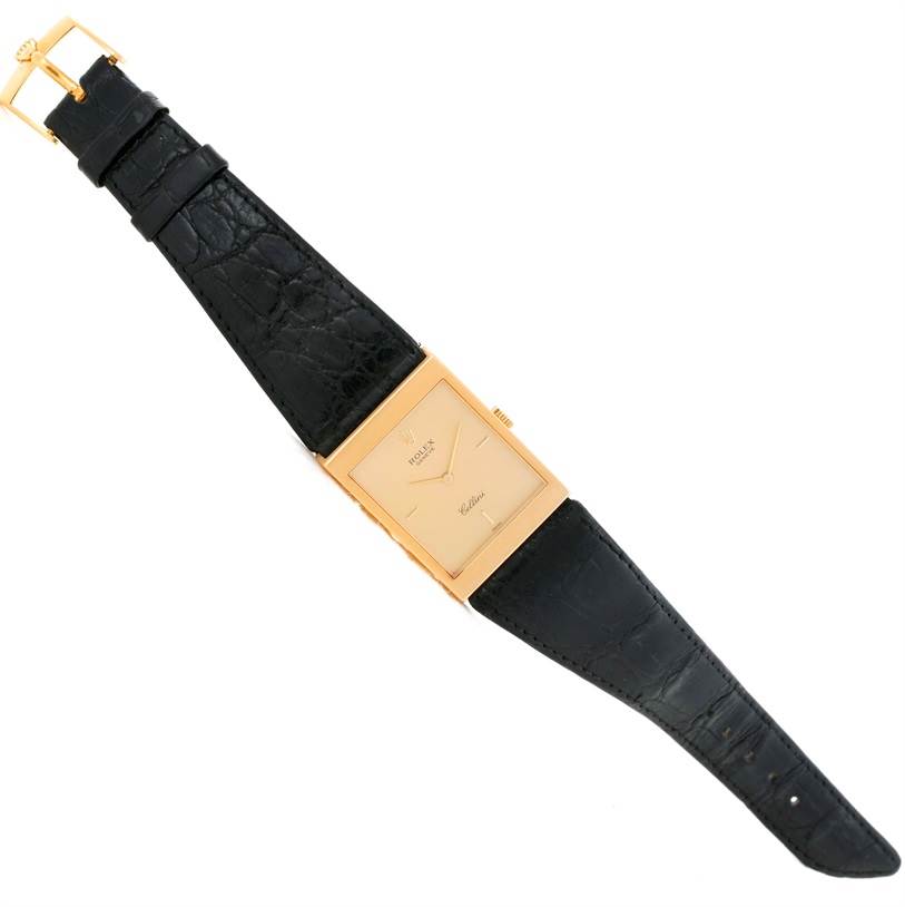 The image shows a top-down view of a Rolex Cellini 5071 Men's Yellow Gold Champagne Dial 5071 Men's Yellow Gold Champagne Dial watch with a rectangular gold case and black leather strap.