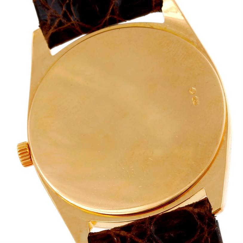 This is the rear view of a Rolex Cellini 4233 Men
s Yellow Gold White Dial 4233 Men
s Yellow Gold White Dial watch case, showcasing the back cover and part of the brown leather strap.