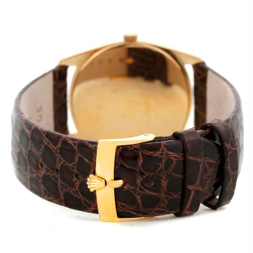 The image shows the rear angle of a Rolex Cellini 4233 Men
s Yellow Gold White Dial 4233 Men
s Yellow Gold White Dial watch, highlighting its brown leather strap and gold clasp.