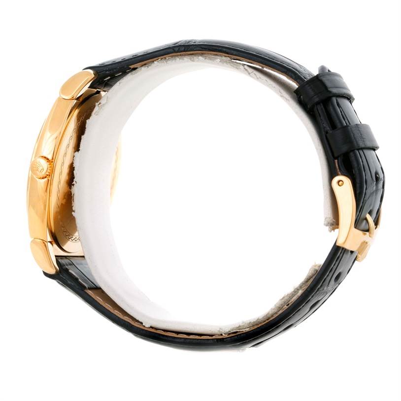 The Rolex Cellini 5330 Men's Yellow Gold White Dial 5330 Men's Yellow Gold White Dial watch is shown from a side angle, displaying its gold case, crown, leather strap, and gold buckle.