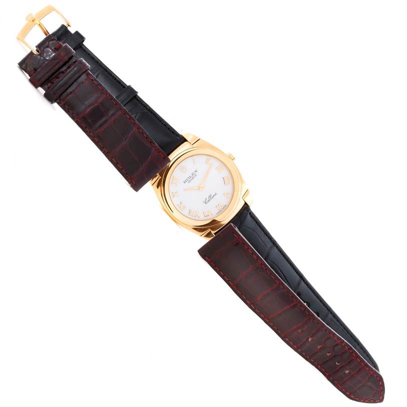 The Rolex Cellini 5330 Men's Yellow Gold White Dial 5330 Men's Yellow Gold White Dial watch is shown from a top-down angle, displaying its round face, gold case, and black leather strap.