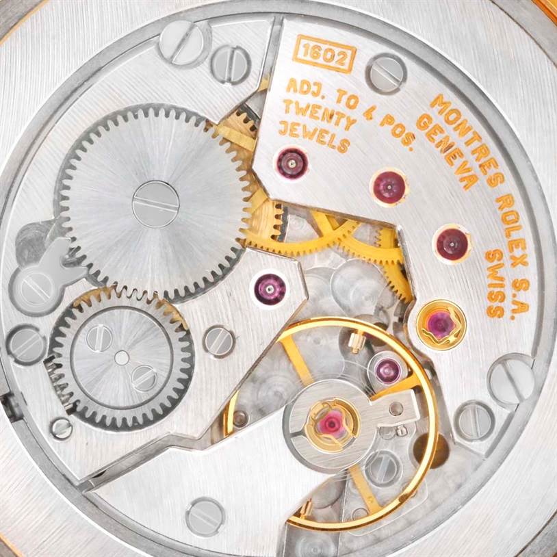 The image shows the intricate internal mechanism of a Rolex Cellini 5116 Men
s Yellow Gold Black Dial 5116 Men
s Yellow Gold Black Dial model watch from a top-down angle, highlighting its gears and jewels.