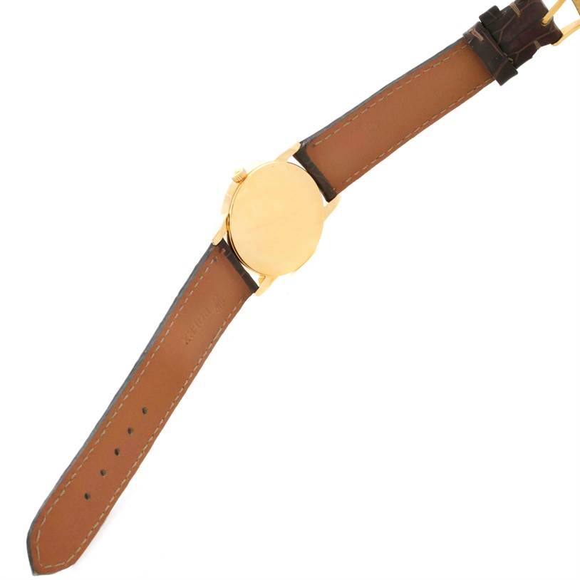 The image shows the back view of a Rolex Cellini 5116 Men
s Yellow Gold Black Dial 5116 Men
s Yellow Gold Black Dial watch, including its leather strap and gold case.