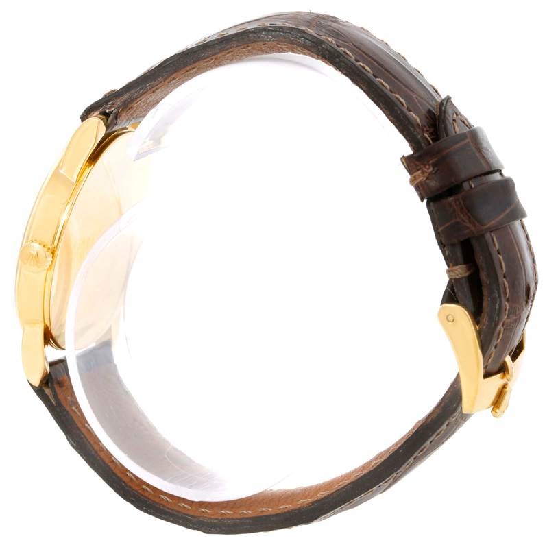 The image shows a side view of a Rolex Cellini 5116 Men
s Yellow Gold Black Dial 5116 Men
s Yellow Gold Black Dial watch, featuring a gold case and brown leather strap with a buckle.