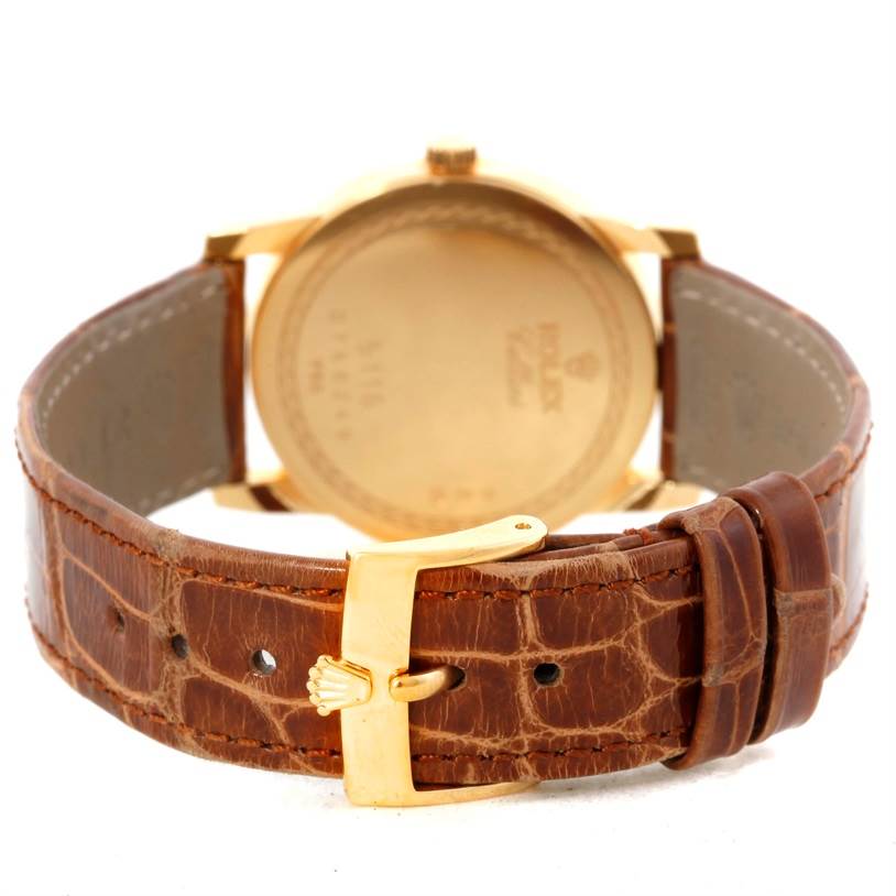 The image shows the back view of a Rolex Cellini 5116 Men
s Yellow Gold Champagne Dial 5116 Men
s Yellow Gold Champagne Dial watch, highlighting the leather strap and buckle.