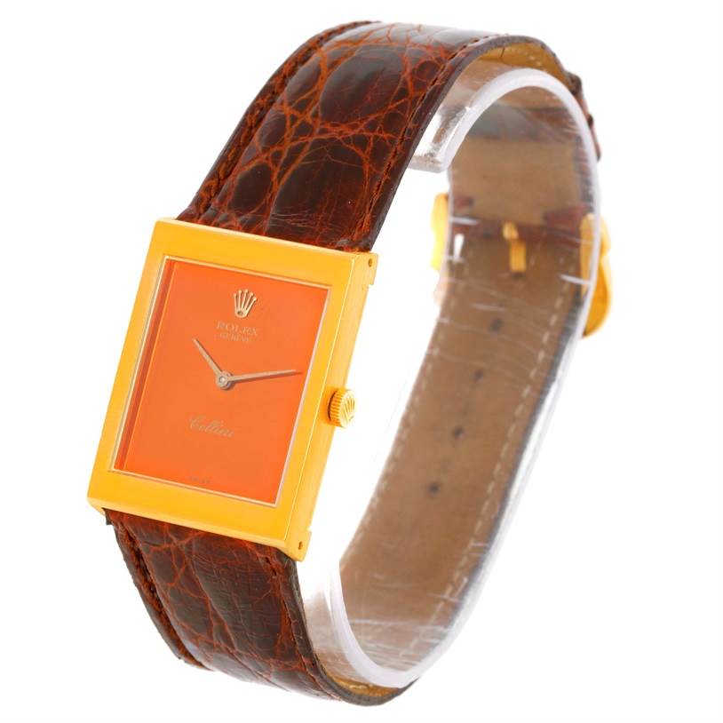 The image shows a Rolex Cellini 4014 Men's Yellow Gold Orange Dial 4014 Men's Yellow Gold Orange Dial watch from an angled view, highlighting the rectangular face, crown, and leather strap.