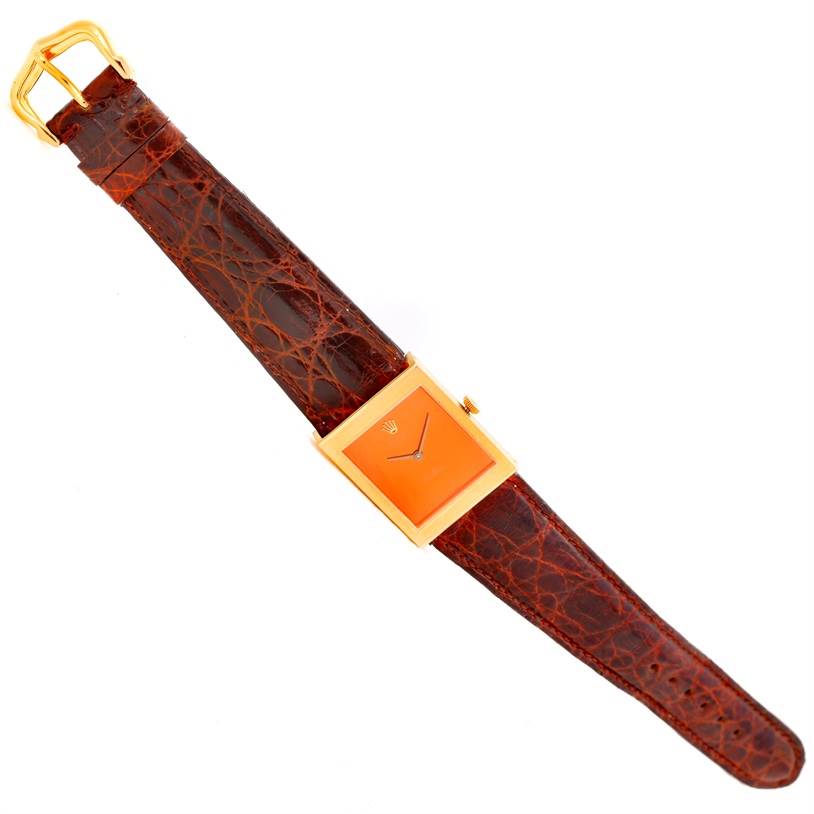 The image shows a top view of a Rolex Cellini 4014 Men's Yellow Gold Orange Dial 4014 Men's Yellow Gold Orange Dial watch, displaying its orange dial, gold case, and brown leather strap.