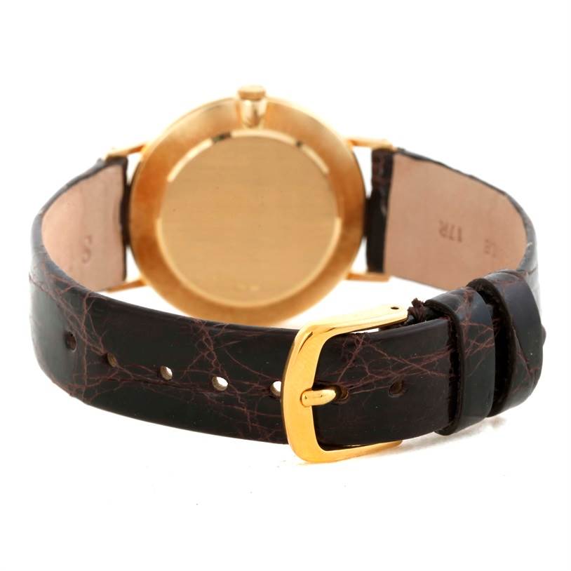 The Rolex Cellini 4112 Men
s Yellow Gold Champagne Dial 4112 Men
s Yellow Gold Champagne Dial watch is shown from the back, highlighting its gold case and dark leather strap with a gold buckle.