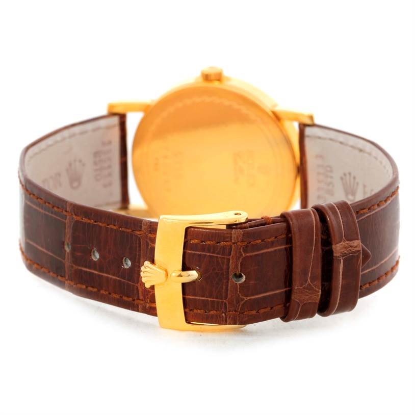 The image shows the back view of a Rolex Cellini 5115 Men
s Yellow Gold Champagne Dial 5115 Men
s Yellow Gold Champagne Dial watch, focusing on the leather strap and gold buckle.