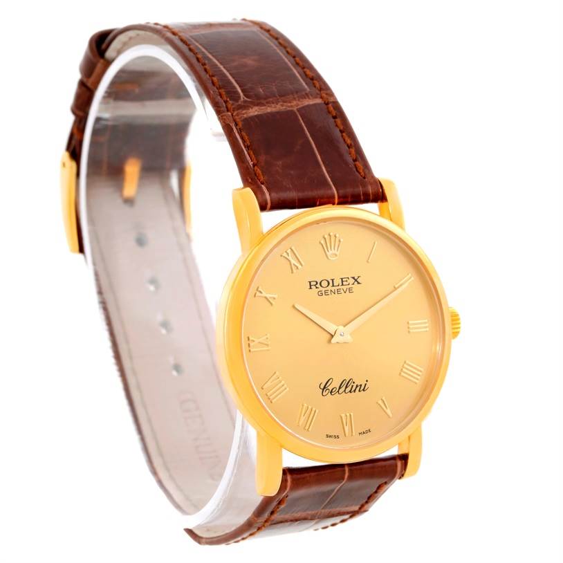 The image shows a side angle of a Rolex Cellini 5115 Men
s Yellow Gold Champagne Dial 5115 Men
s Yellow Gold Champagne Dial watch, highlighting its brown leather strap and gold dial with Roman numerals.