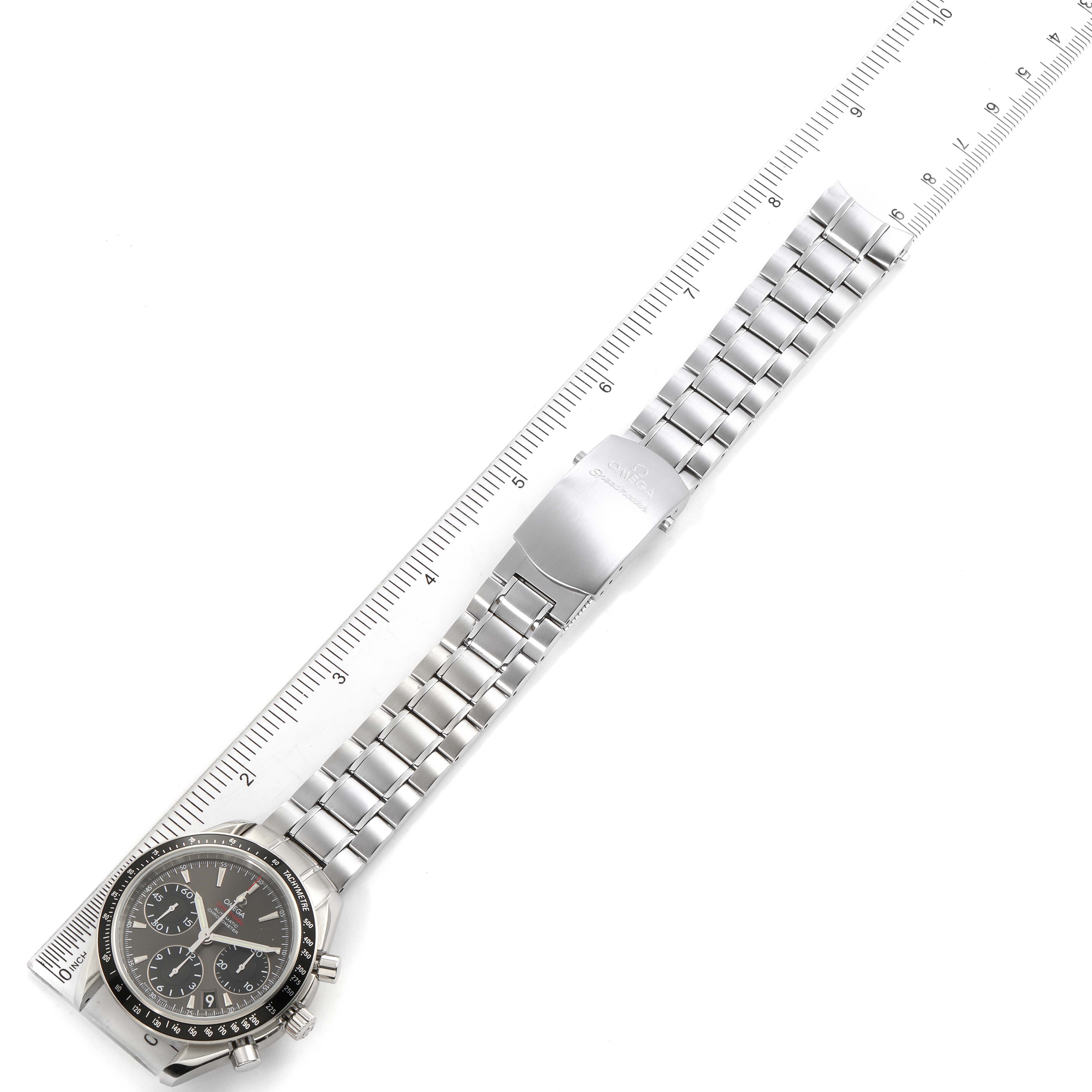 The image shows an Omega Speedmaster 323.30.40.40.06.001 Men's Stainless Steel Grey Dial 323.30.40.40.06.001 Men's Stainless Steel Grey Dial watch with its stainless steel band laid along a ruler for measuring.