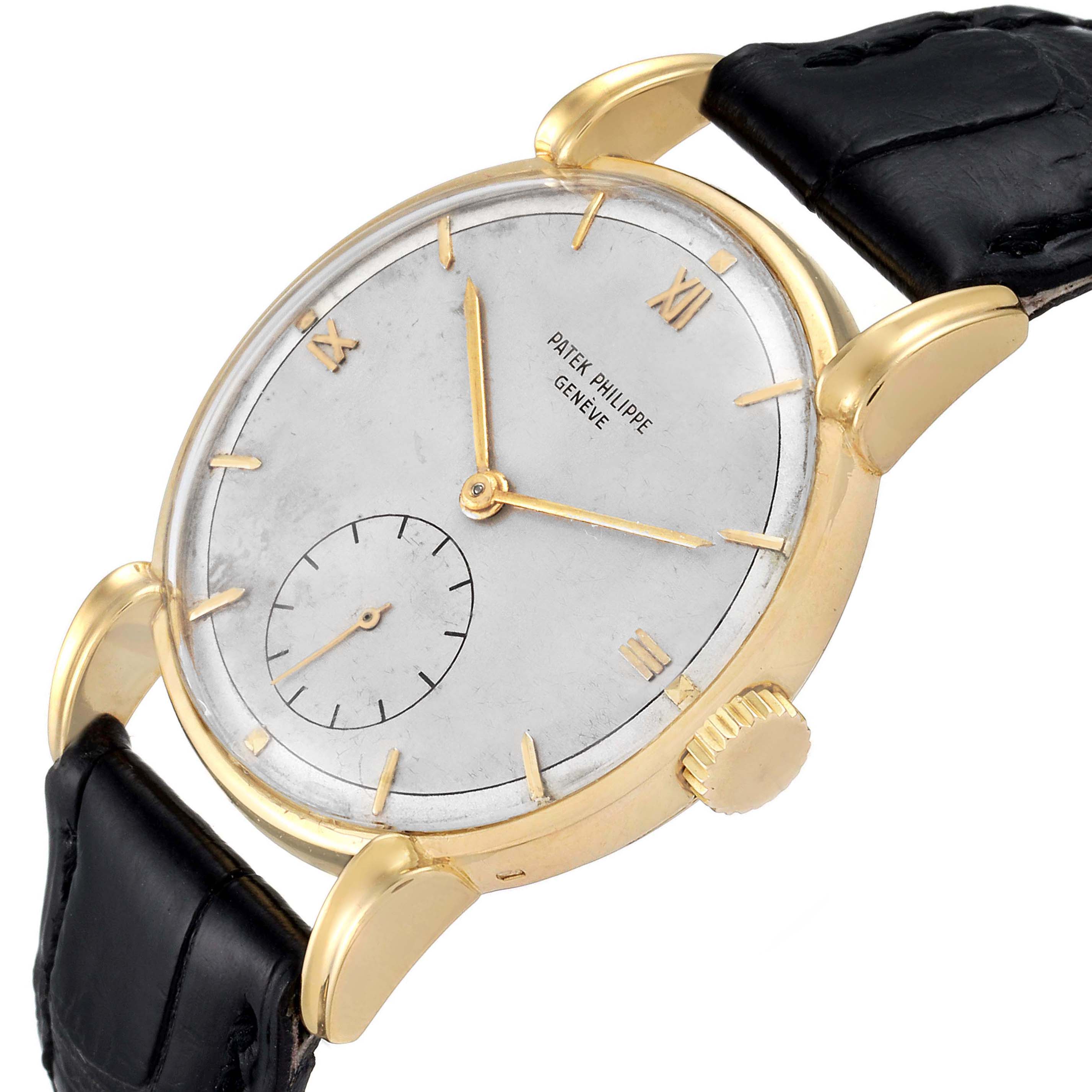 This vintage Patek Philippe watch is shown from a slight side angle, displaying its dial, crown, lugs, and a portion of the leather strap.