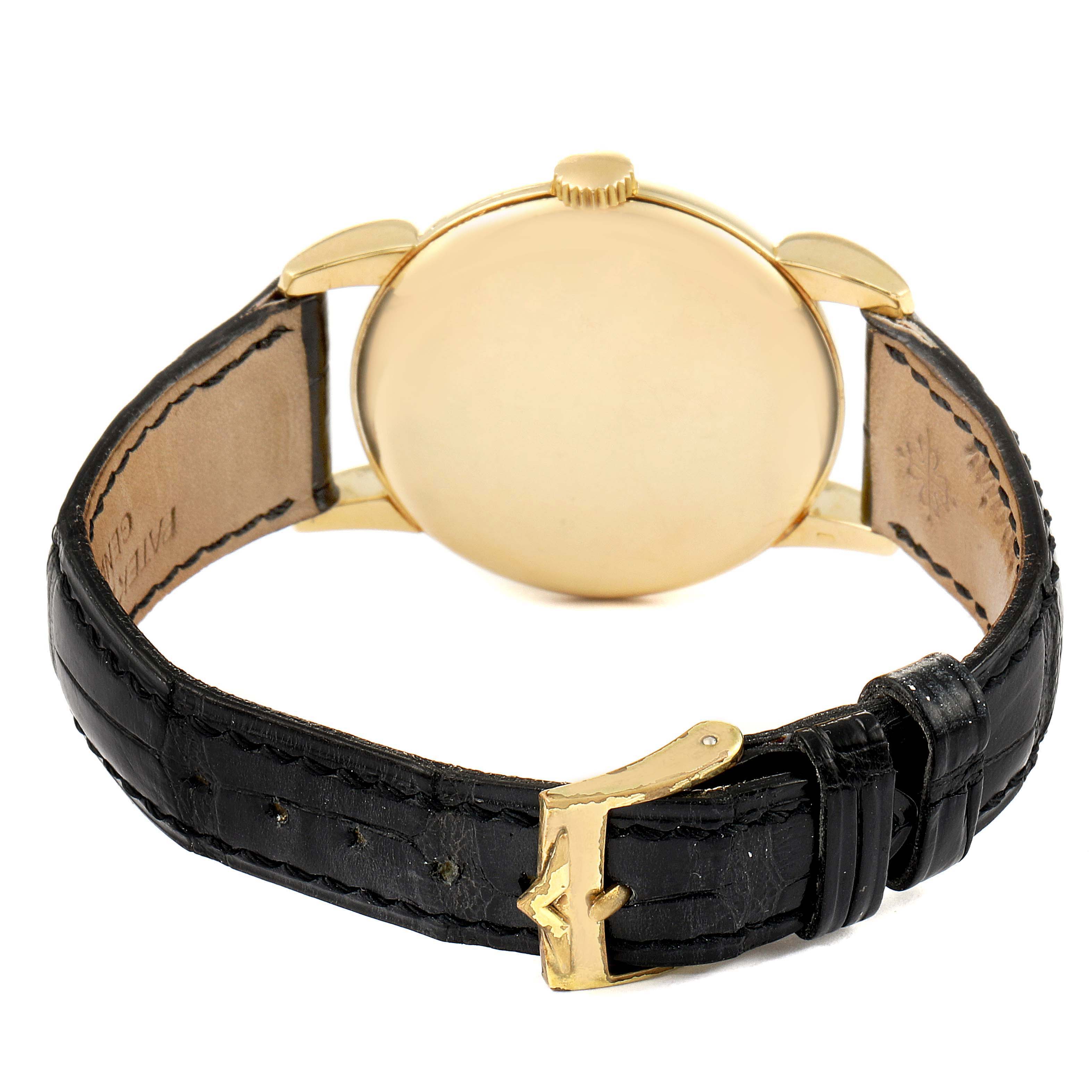 The image shows a rear view of the Patek Philippe Vintage watch, highlighting its gold case, crown, and black leather strap with a gold buckle.
