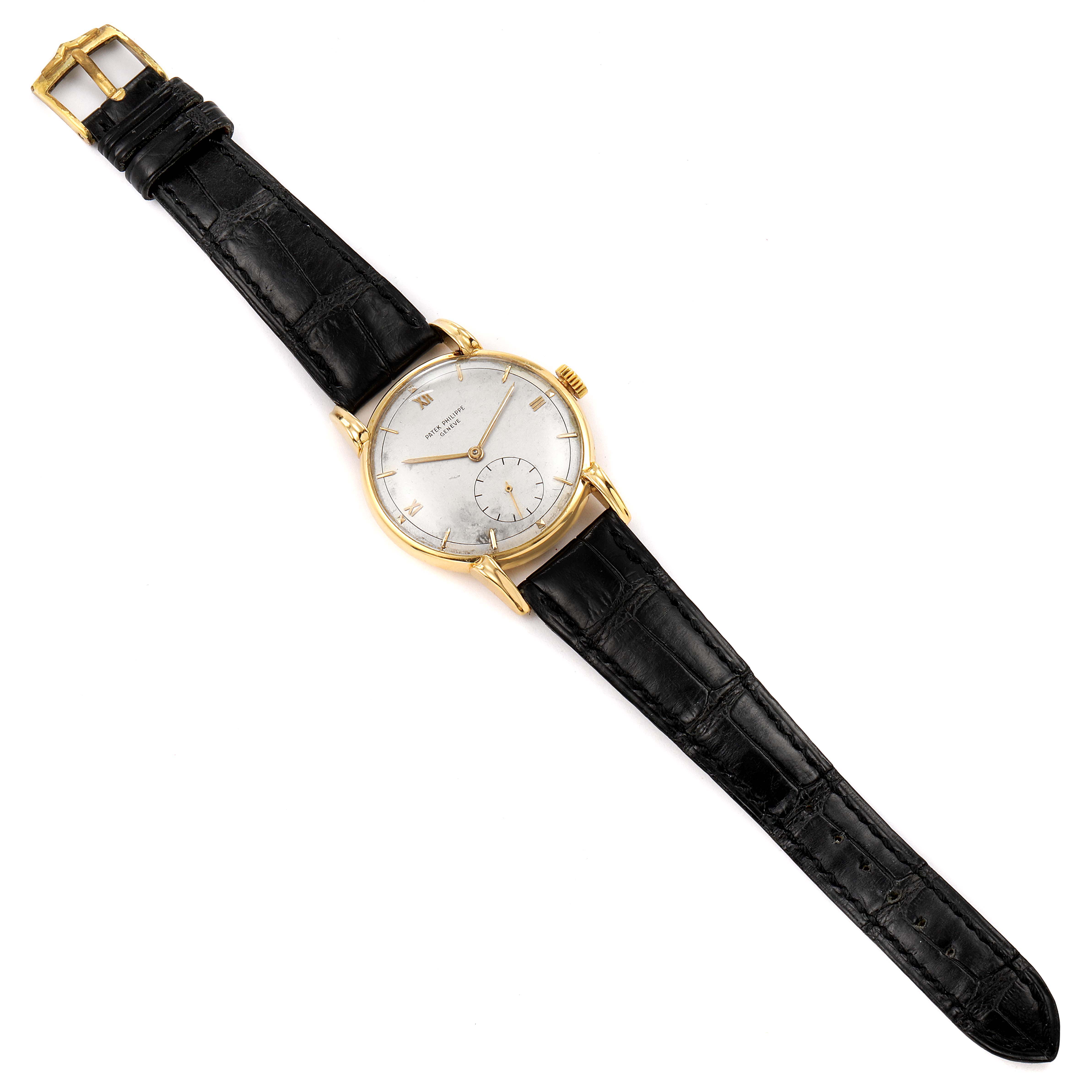 This image shows a Patek Philippe Vintage watch, positioned flat, showcasing its black leather strap and gold case.