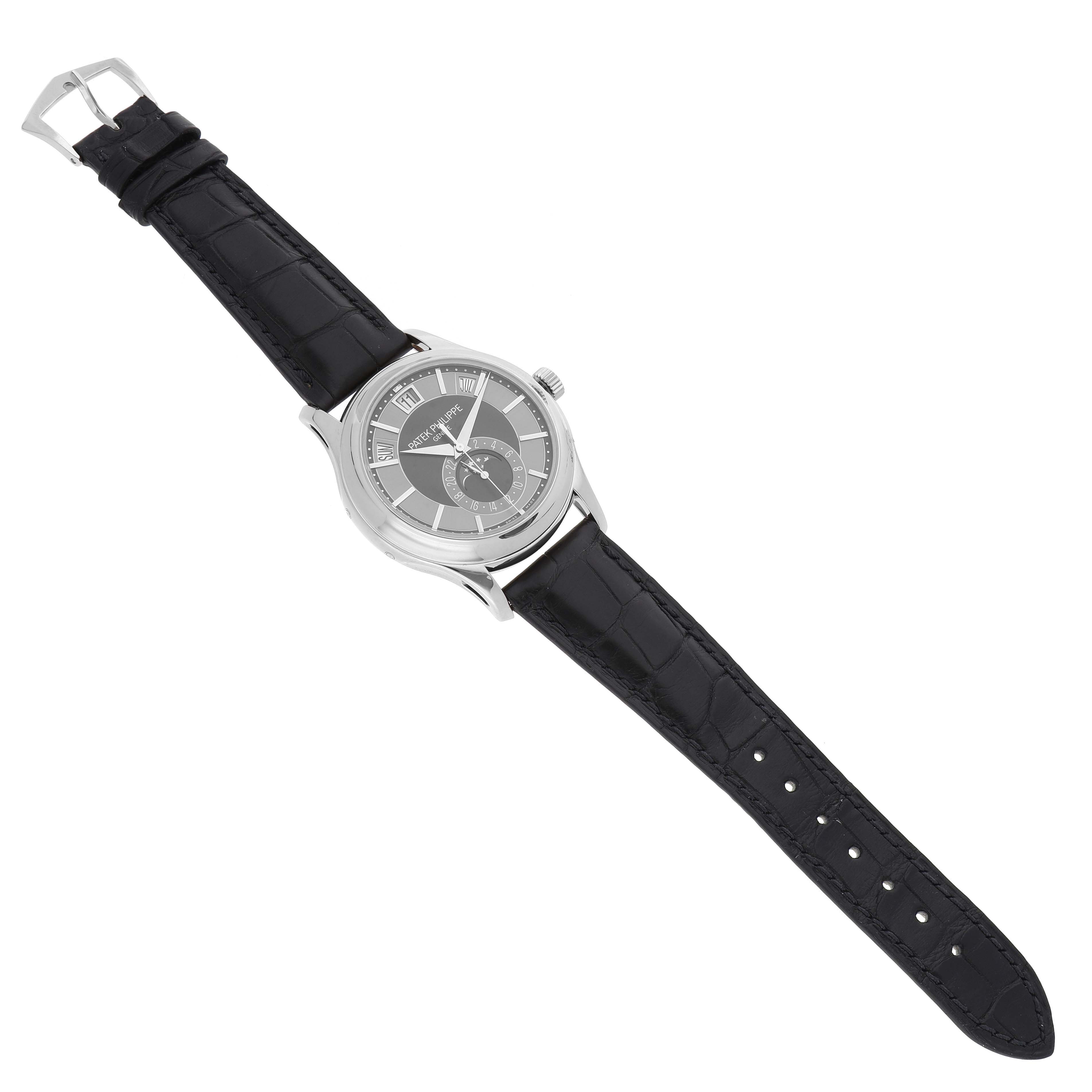 The Complications model by Patek Philippe is shown from a top-down angle, displaying the full watch including the dial and black leather strap.