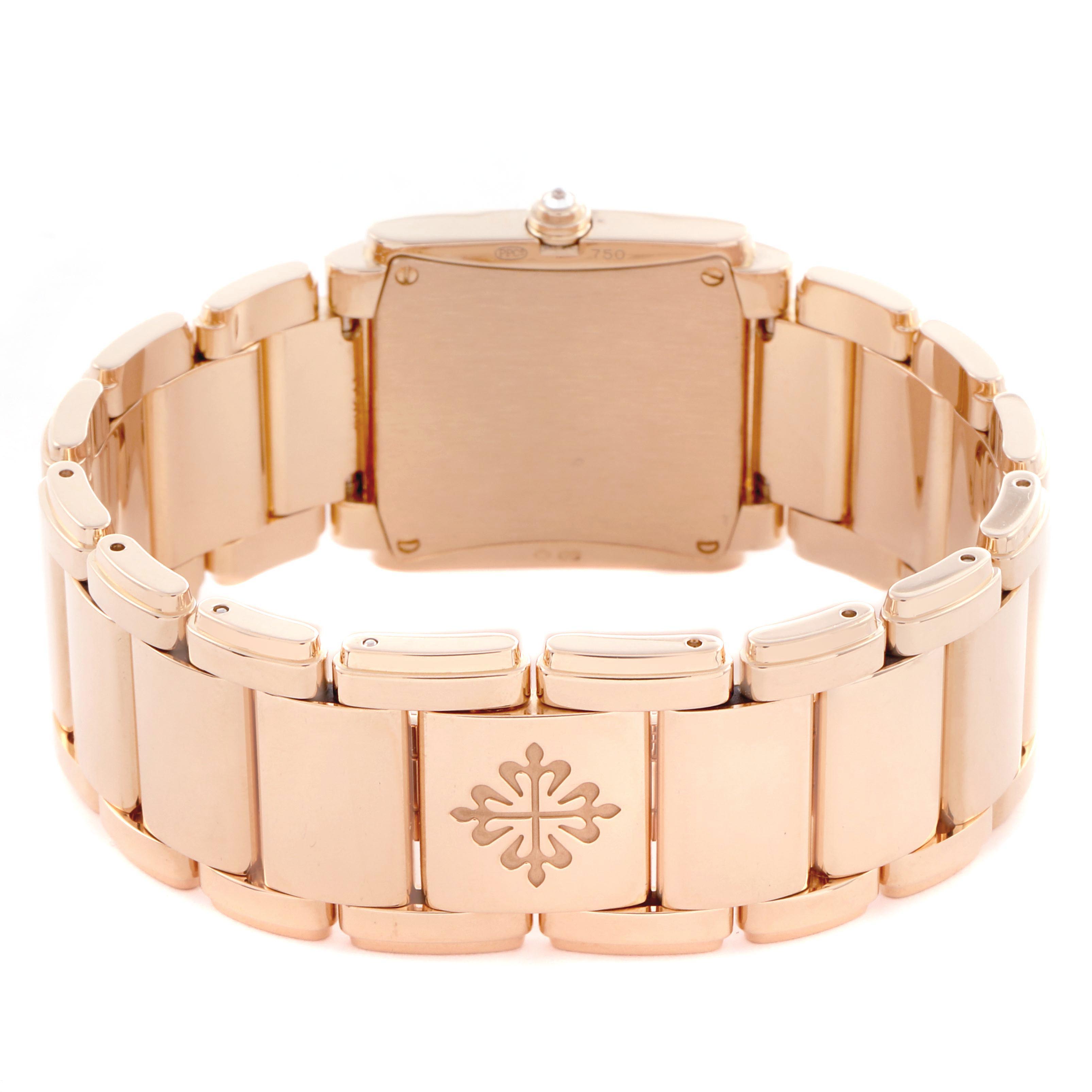 The image shows the back of the Patek Philippe Twenty-4 4910/11R-011 Women's Rose Gold Silver Dial 4910/11R-011 Women's Rose Gold Silver Dial watch at an angle, highlighting its bracelet and clasp with the logo.