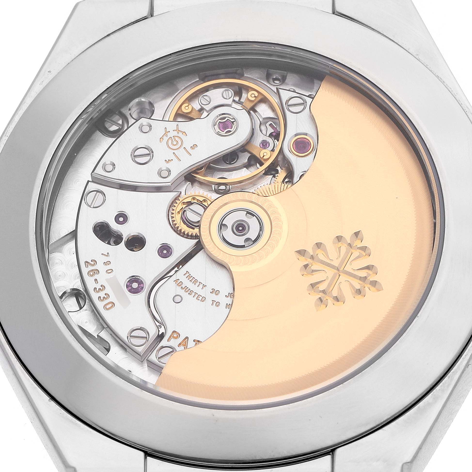 The image shows the back view of a Patek Philippe Twenty-4 7300/1200A-011 Women's Stainless Steel Green Dial watch, highlighting its intricate movement and rotor.