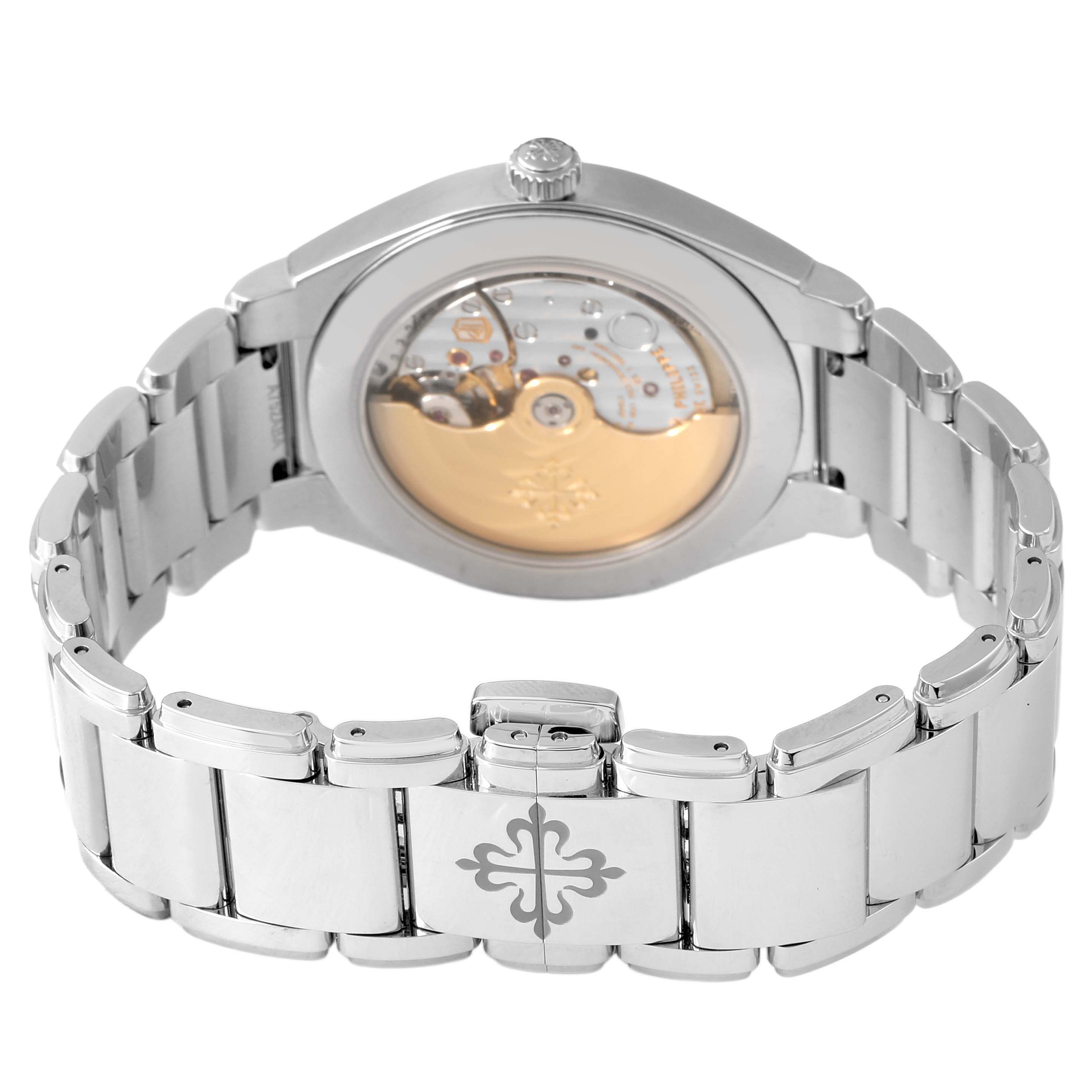 The Patek Philippe Twenty-4 7300/1200A-011 Women's Stainless Steel Green Dial watch is shown from the back, highlighting the open case back and metal bracelet clasp.