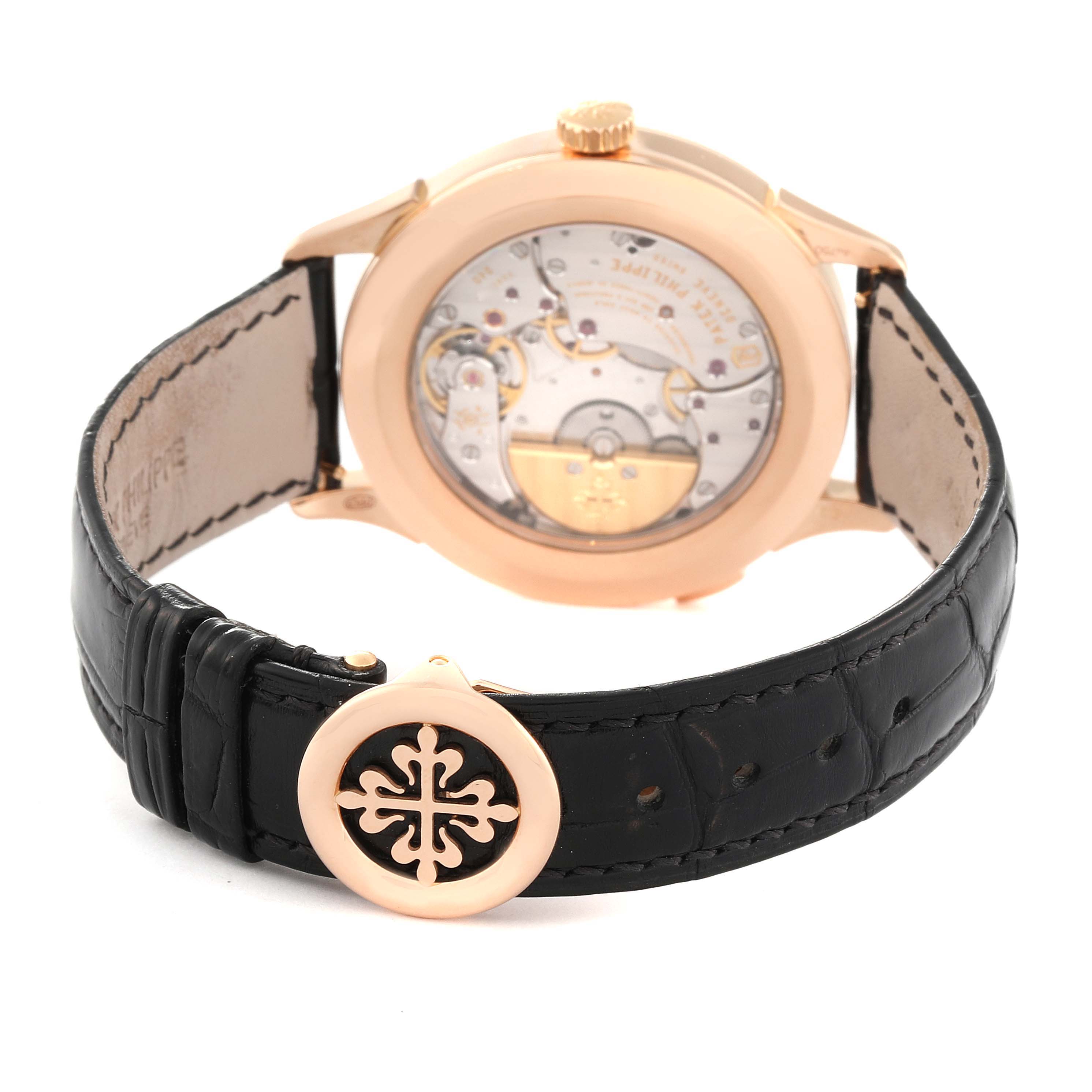 The image shows the back view of a Patek Philippe Complications 5230R-001 Men's Rose Gold Grey Dial 5230R-001 Men's Rose Gold Grey Dial watch, highlighting the movement and leather strap.