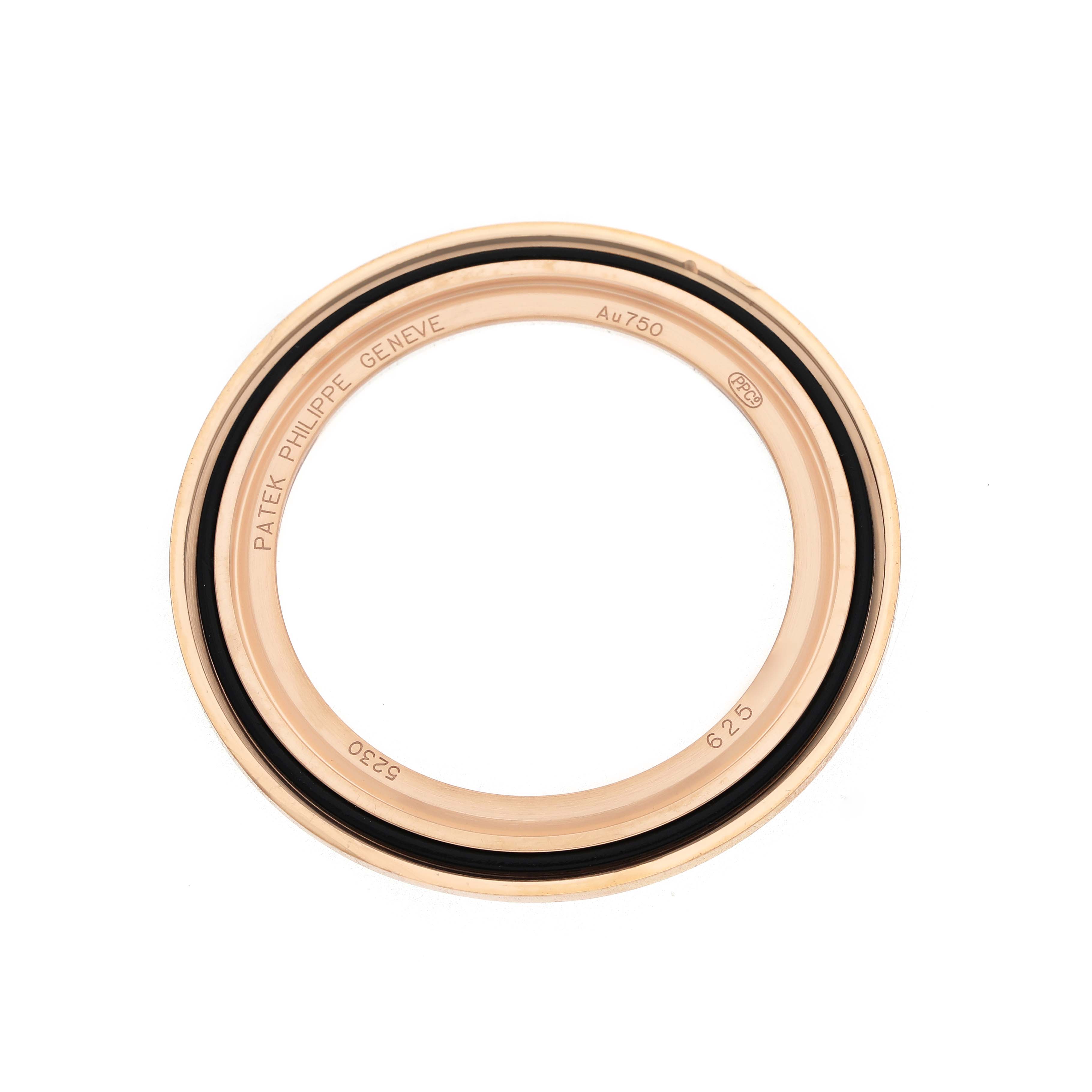 The image shows a Patek Philippe Complications 5230R-001 Men's Rose Gold Grey Dial watch bezel, viewed from above, featuring inscriptions and a rubber seal.