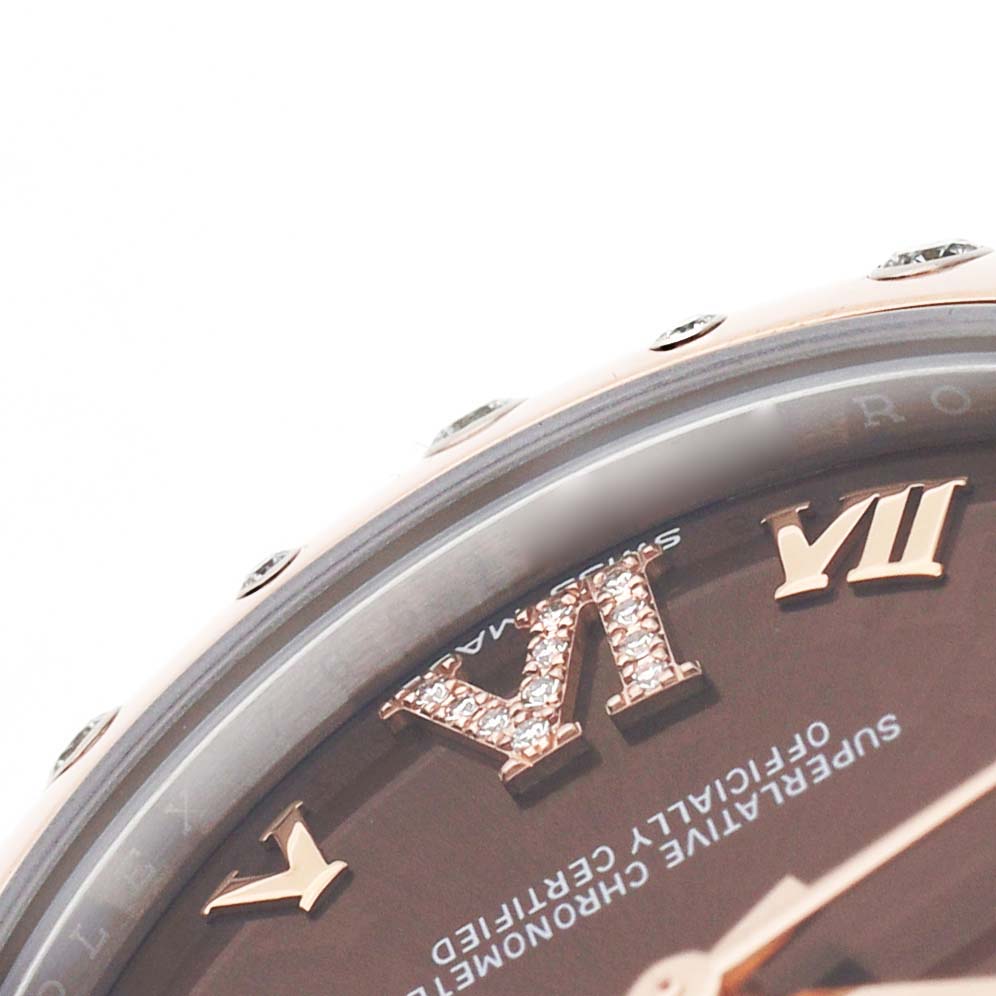 The image shows an angled close-up of a Rolex Mid-Size 178341 Women's Steel and Gold (two tone) Brown Dial watch, highlighting the Roman numerals VI and VII and part of the bezel.