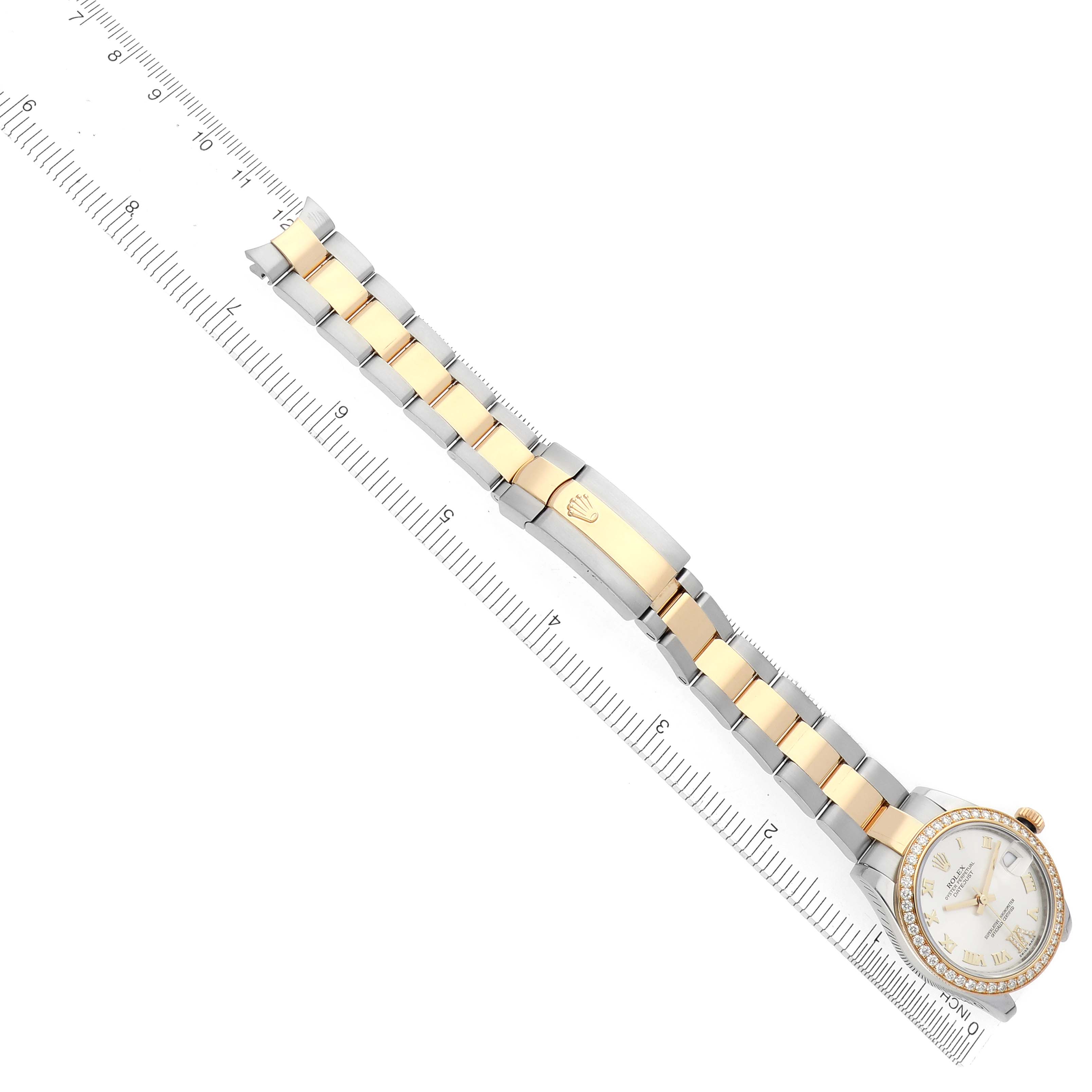 The Rolex Datejust 178383 Women's Steel and Gold (two tone) Silver Dial 178383 Women's Steel and Gold (two tone) Silver Dial is shown from a top view, highlighting the bracelet and clasp alongside a ruler for scale.