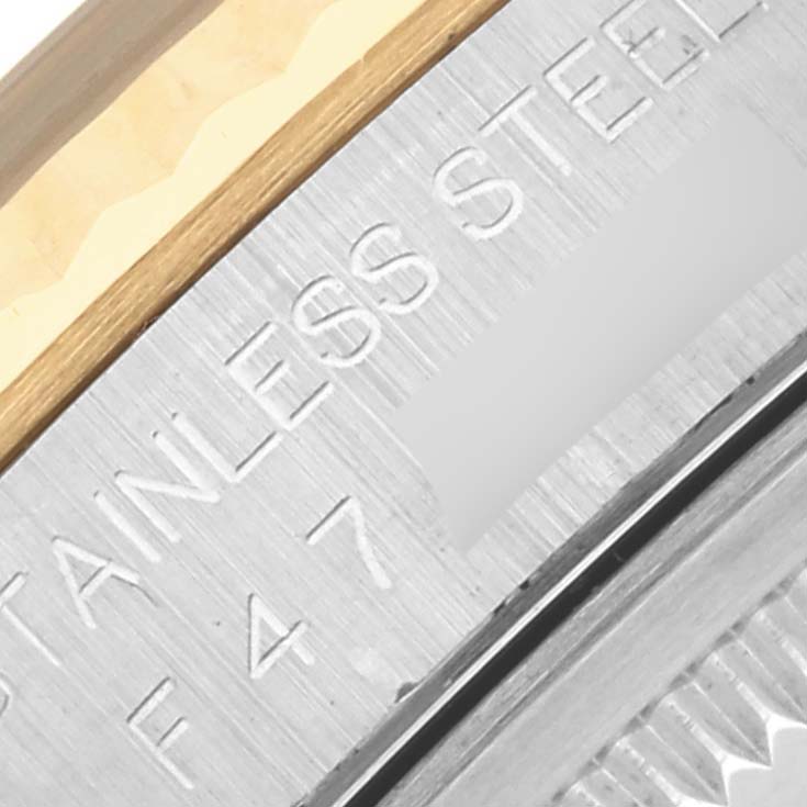 This image shows a close-up of the stainless steel and gold edge of a Rolex Datejust 16233 Men's Steel and Gold (two tone) Champagne Dial 16233 Men's Steel and Gold (two tone) Champagne Dial watch case with engraved text.