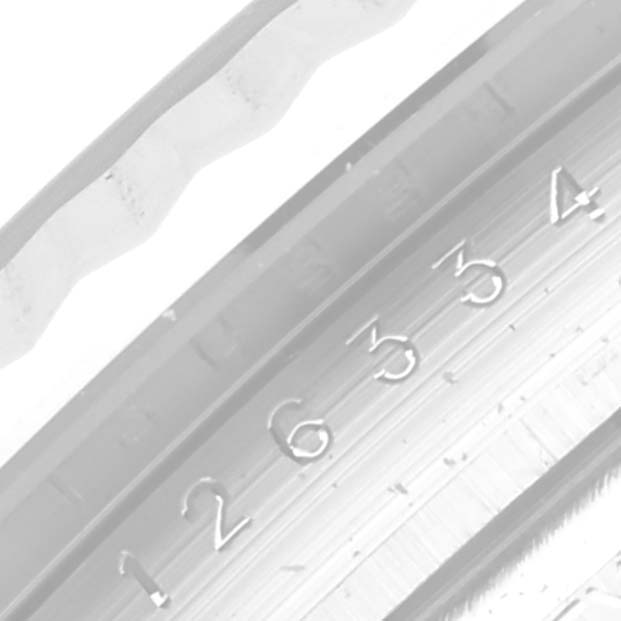 This image shows a close-up of the fluted bezel and engraved inner ring of a Rolex Datejust 41 126334 Men
s Stainless Steel Blue Dial 126334 Men
s Stainless Steel Blue Dial watch.