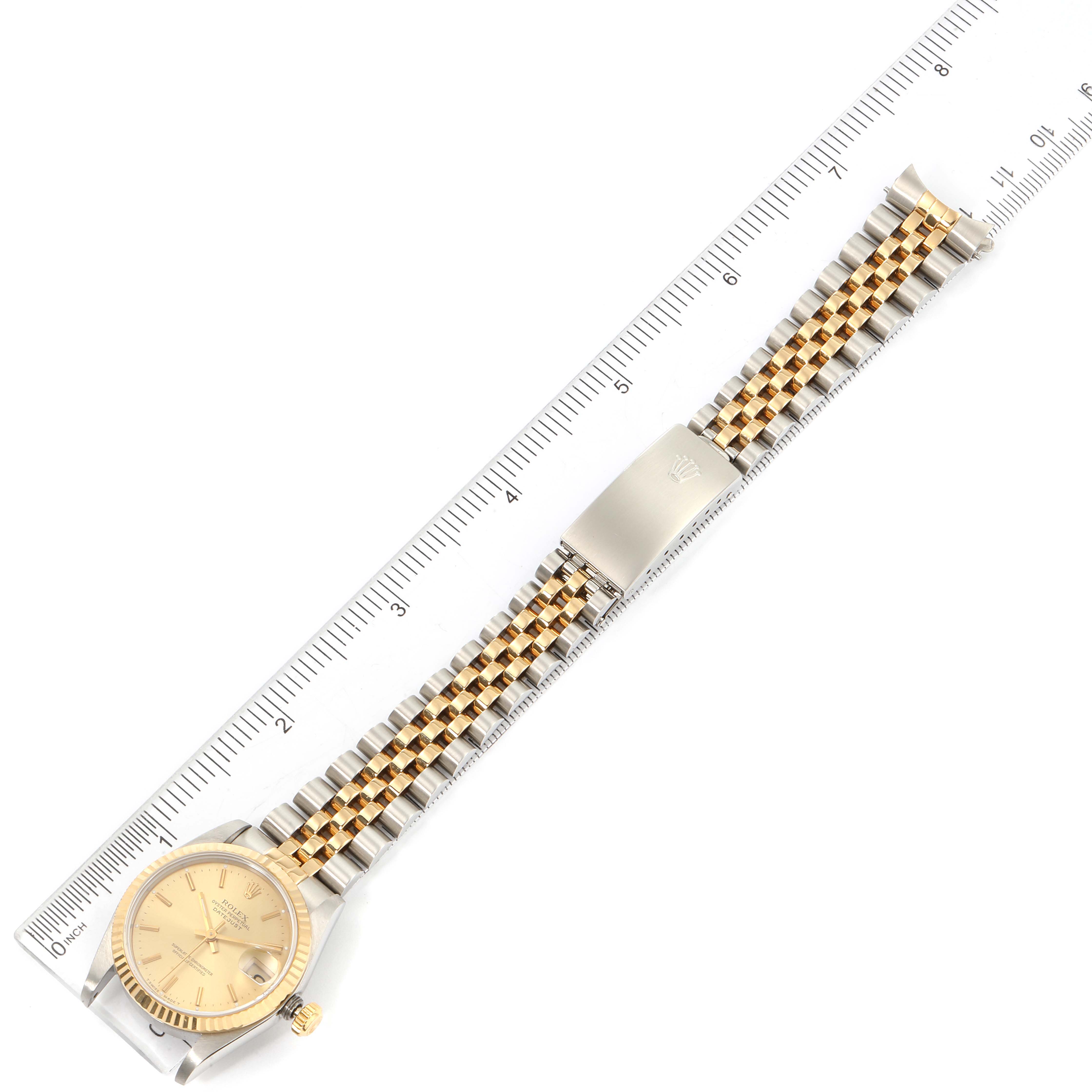 The image shows a Rolex Mid-Size 68273 Women's Steel and Gold (two tone) Champagne Dial 68273 Women's Steel and Gold (two tone) Champagne Dial watch laid flat with a ruler beside it, displaying the full watch band and watch face.