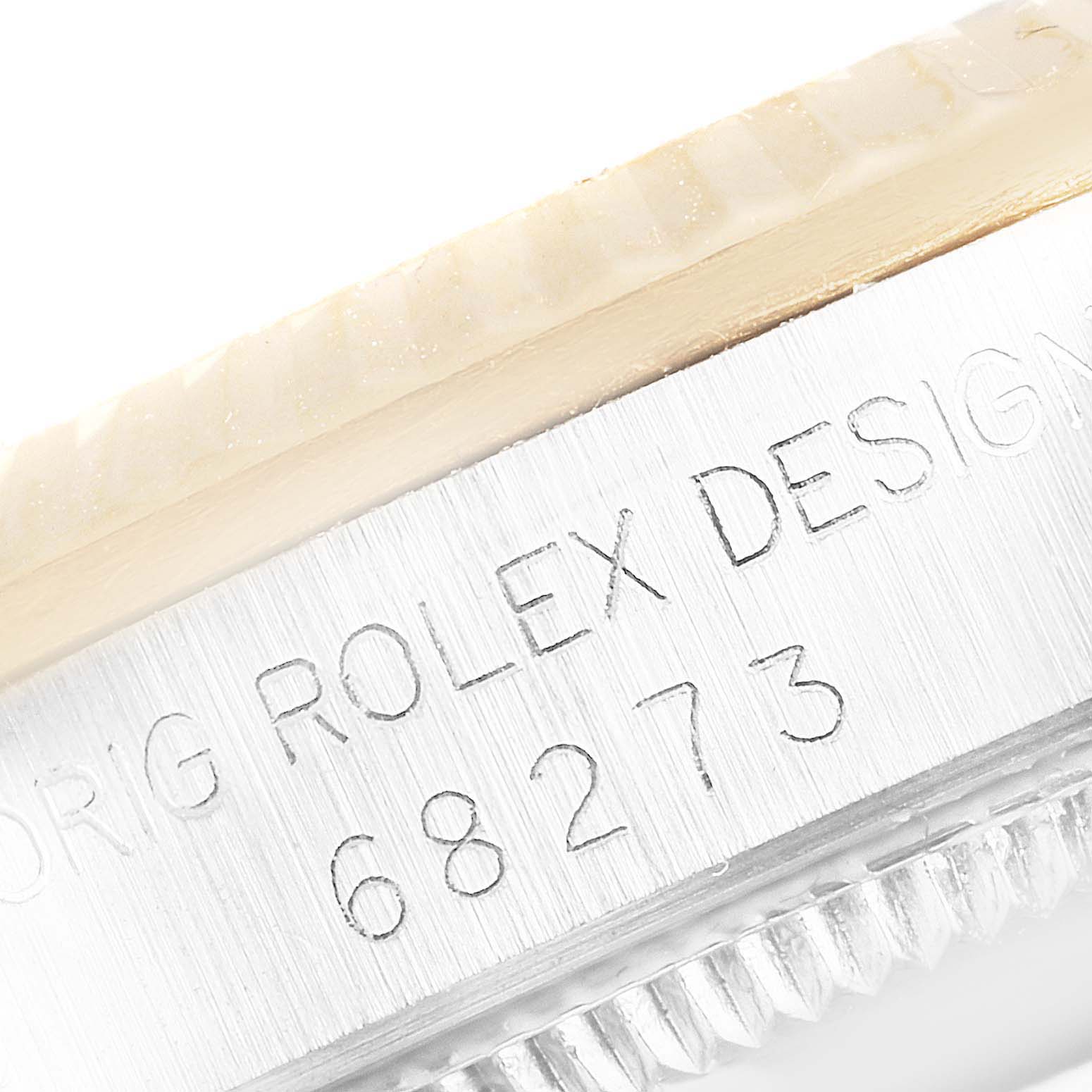 This close-up image shows the engraved side of the case of a Rolex Mid-Size 68273 Women's Steel and Gold (two tone) Champagne Dial 68273 Women's Steel and Gold (two tone) Champagne Dial model 68273.