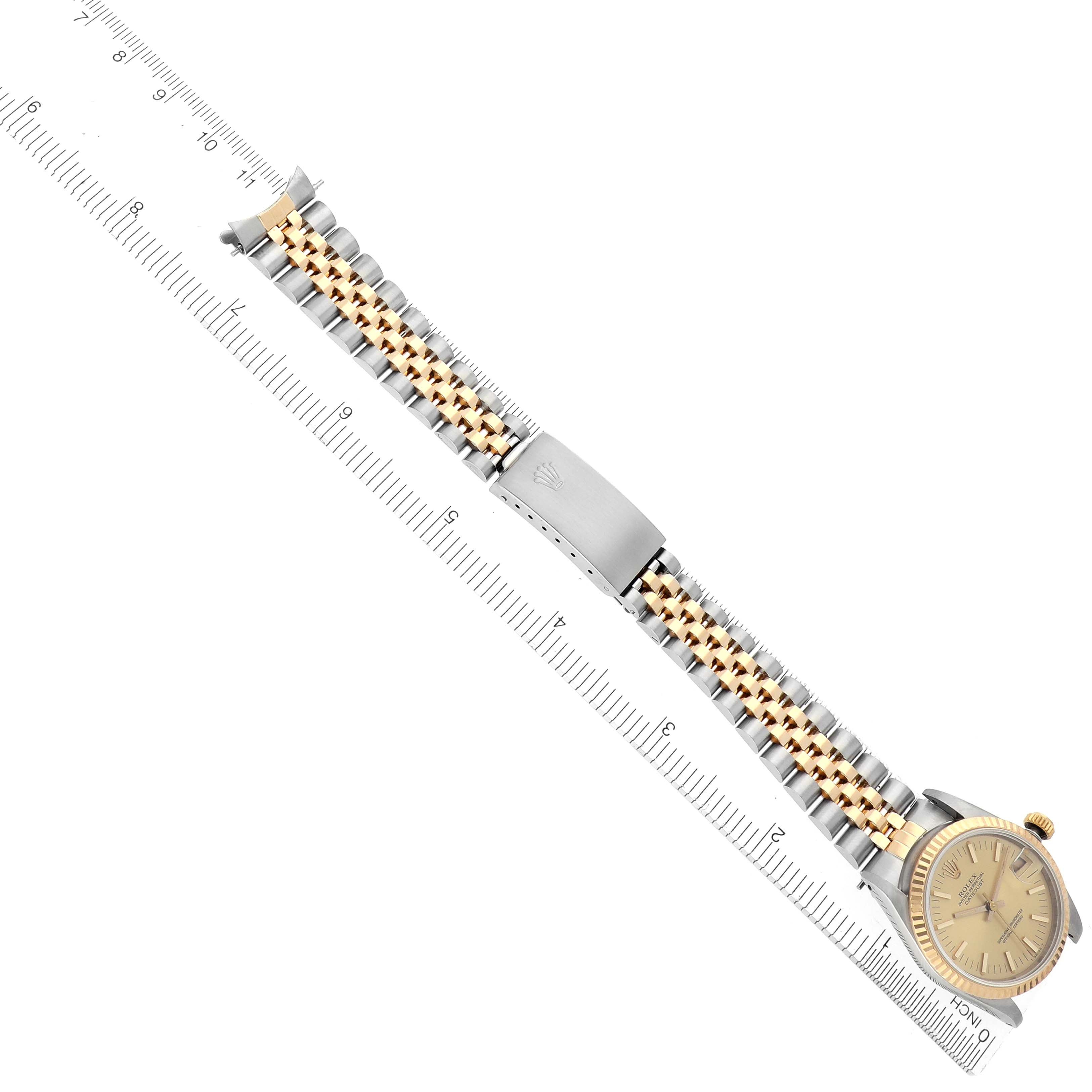 The image shows a Rolex Mid-Size 68273 Women's Steel and Gold (two tone) Champagne Dial 68273 Women's Steel and Gold (two tone) Champagne Dial watch laid flat with its bracelet extended alongside a ruler, showcasing the face and clasp.