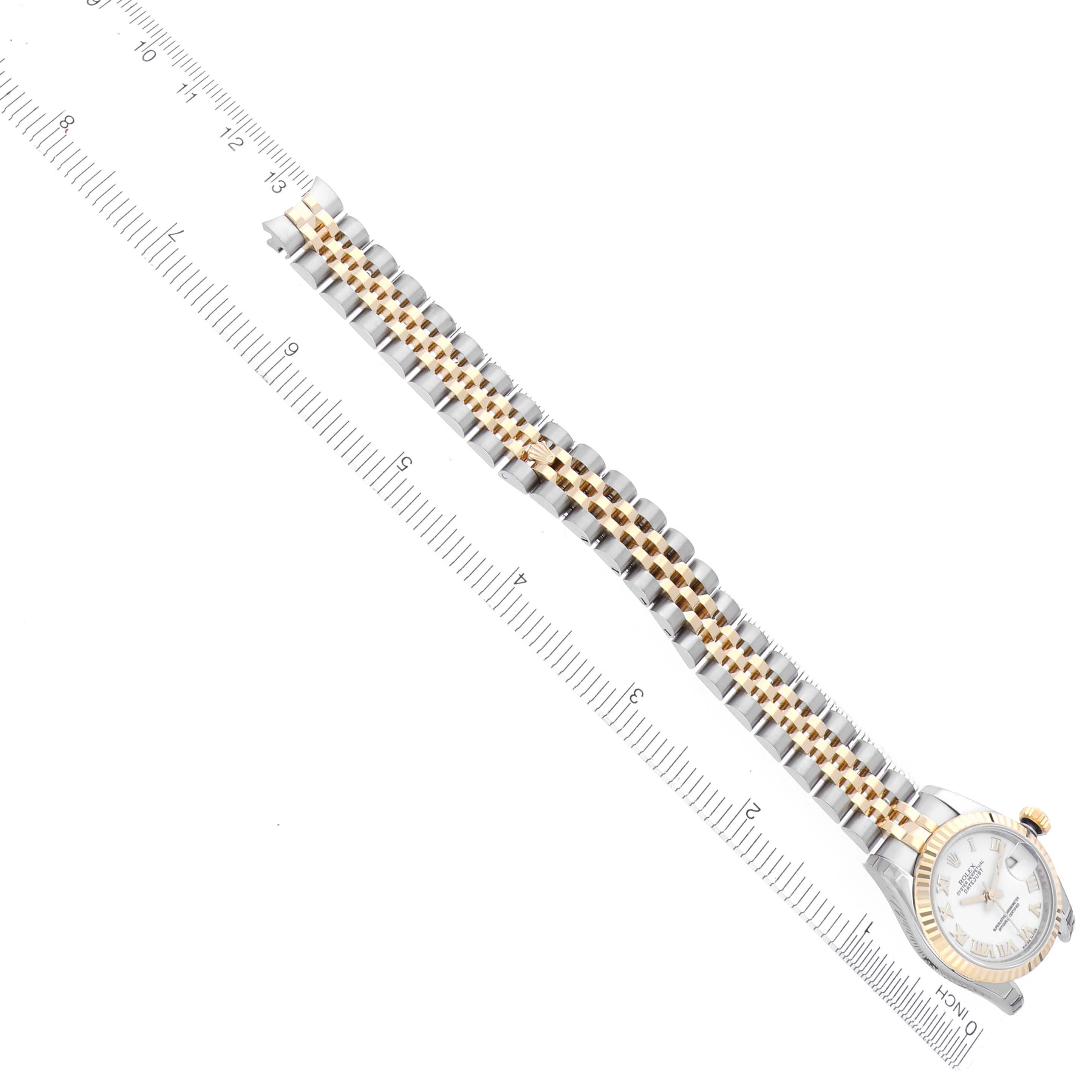 The image shows a Rolex Datejust 179173 Women's Steel and Gold (two tone) White Dial 179173 Women's Steel and Gold (two tone) White Dial watch at an angle, featuring the band and part of the face alongside a ruler for scale.