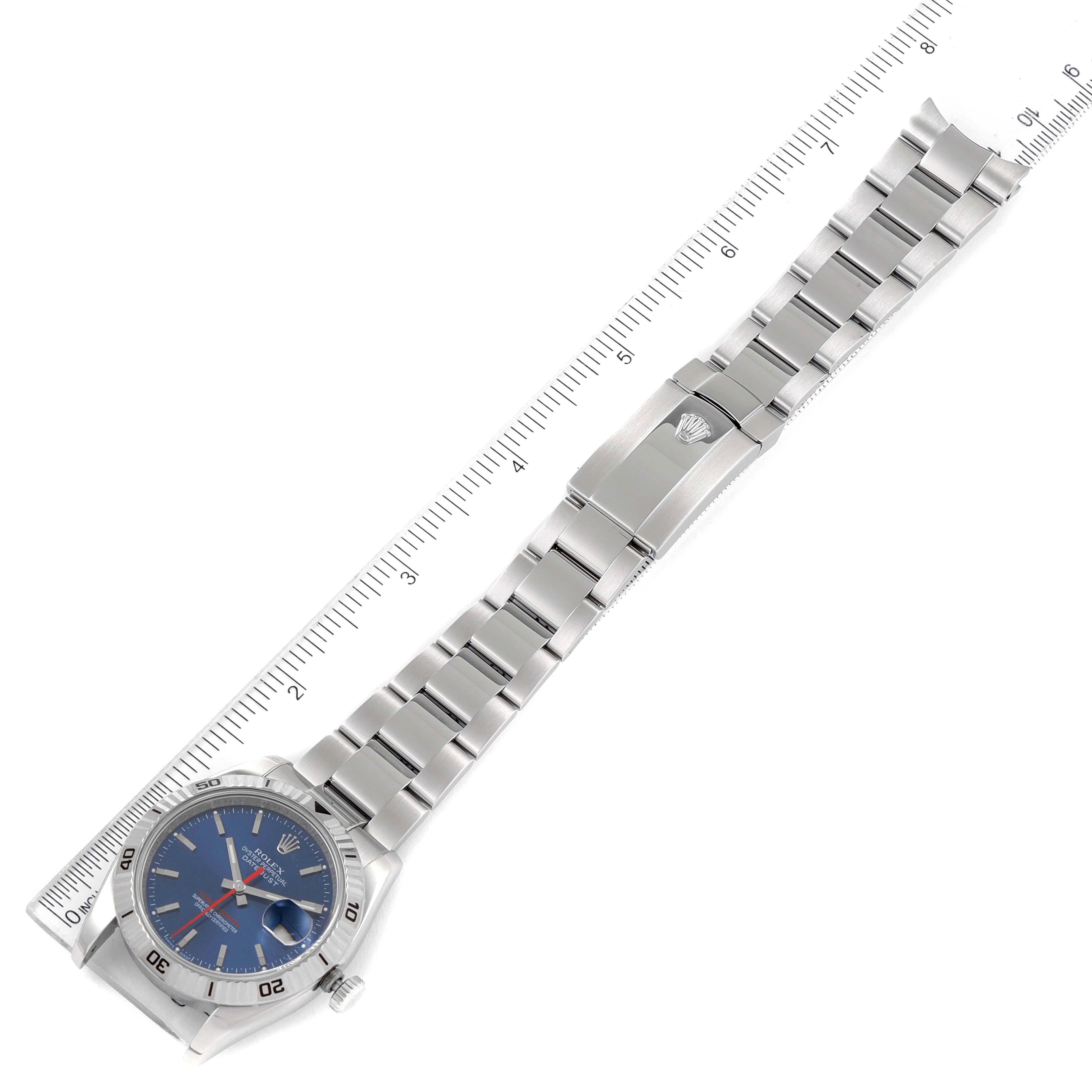 The image shows a Rolex Turn-o-Graph 116264 Men
s Stainless Steel Blue Dial 116264 Men
s Stainless Steel Blue Dial watch lying flat with its strap extended, next to a ruler for scale.