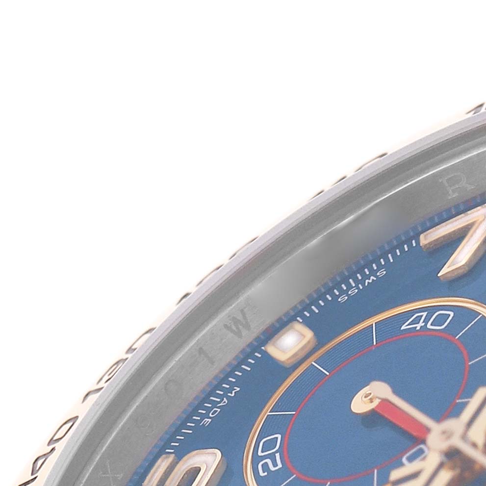 This close-up of the Rolex Daytona 116503 Men's Steel and Gold (two tone) Blue Dial watch shows the edge of the bezel and part of the blue dial.