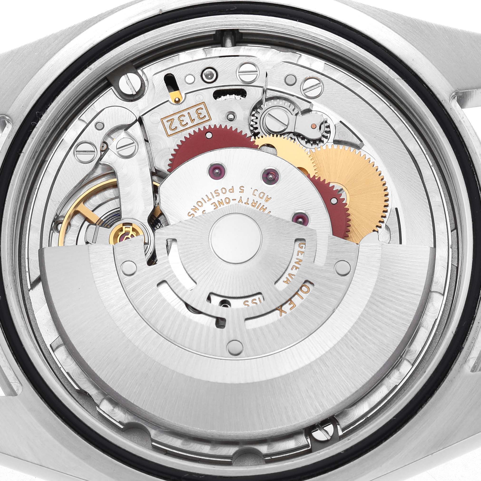 The image shows the movement of a Rolex Explorer 214270 Men's Stainless Steel Black Dial watch from a top-down angle, highlighting gears and the rotor.